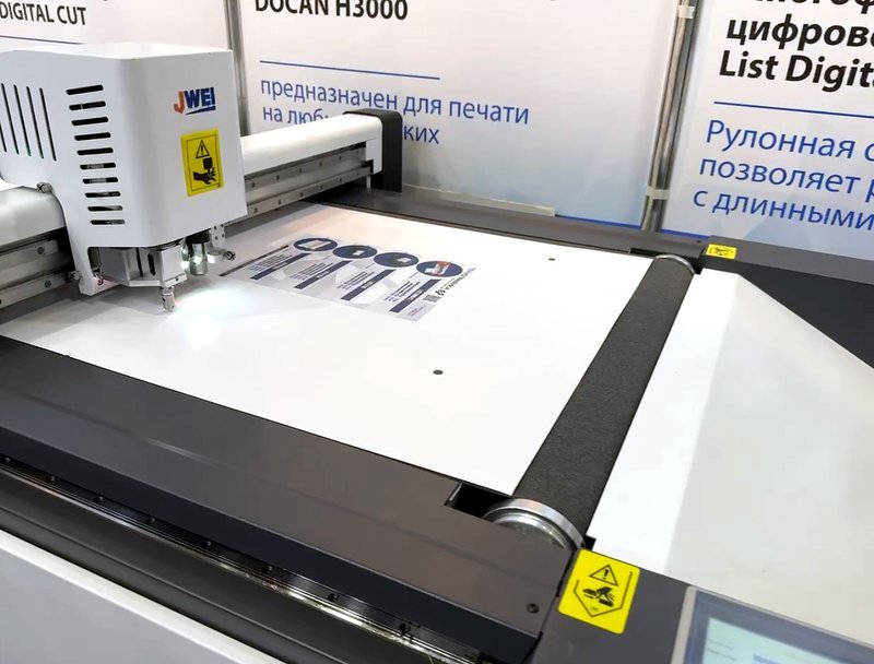 Режущая головка обходит контур наклейки